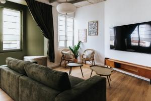 a living room with a couch and a flat screen tv at Maison Hubert B&B in Bordeaux