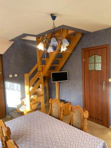 a dining room with a table and a spiral staircase at Agroturystyka u Dudków in Jeleśnia