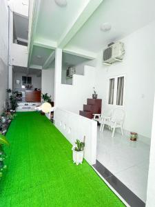 a living room with green grass on the floor at Kim Long Hotel in Phan Thiet