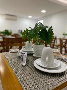 a table with plates and utensils on top of a table at Hotel Areião in Goiânia