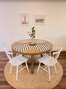 a wooden table with two white chairs and a vase on it at Black Pearl Apartments in Old Town in Szczecin