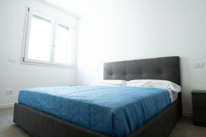 um quarto com uma cama grande e um cobertor azul em [Da Lorenzo] - between station and center em Monza