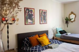 a bedroom with a bed with orange and yellow pillows at Boho Chic Apt in Vila Franca de Xira