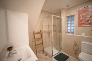 La salle de bains est pourvue d'une douche et d'un lavabo. dans l'établissement Boho Chic Apt, à Vila Franca de Xira
