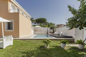 a backyard with a swimming pool and a house at Luxury Villa Urania with pool - Stella del Mare Fontanebianche in Fontane Bianche