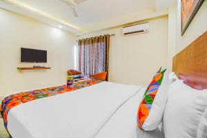 a bedroom with a white bed and a tv at FabHotel VR Stay in Gurgaon