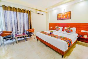 a bedroom with a large bed and a table and chairs at FabHotel VR Stay in Gurgaon