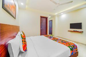 a bedroom with a bed and a tv on the wall at FabHotel VR Stay in Gurgaon