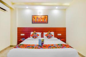 a bedroom with a large bed with a wooden headboard at FabHotel VR Stay in Gurgaon