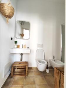 a bathroom with a toilet and a sink and a mirror at Casa Marina Guesthouse Cagliari in Cagliari