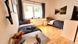 Pokój z 2 łóżkami, stołem i telewizorem w obiekcie Modernes Apartment für 5 Personen w mieście Schwerte
