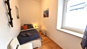 een kleine slaapkamer met een bed en een raam bij Modernes Apartment für 5 Personen in Schwerte