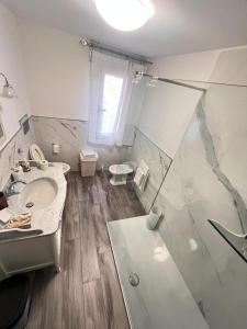 a white bathroom with a shower and a sink at Apartment Diva Canova Laguna Veneta in Codevigo