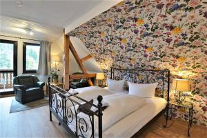 1 dormitorio con 1 cama con pared de flores en Pension Pfefferstübchen en Brotterode