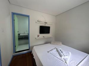 Ouro Preto Suítes في أورو بريتو: غرفة نوم بسرير ومرآة وتلفزيون