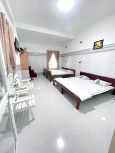 a hospital room with two beds and chairs at Kim Long Hotel in Phan Thiet
