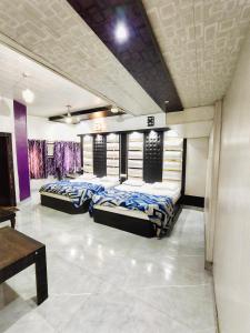 una camera con tre letti in una stanza viola di Hotel Stay Revoli - Just Half k.m From Golden Temple ad Amritsar
