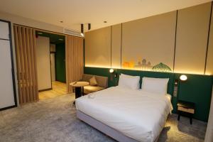 um quarto com uma grande cama branca e um sofá em Holiday Inn Tashkent City, an IHG Hotel em Tashkent