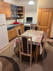 a kitchen with a table and chairs and a white refrigerator at Apartmány Bistár in Zuberec