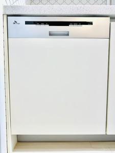 a white dishwasher in a kitchen with a counter top at JY House 1 in Busan