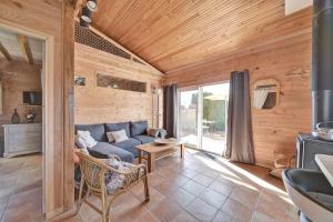 sala de estar con sofá azul y paredes de madera en Maisonnette à la campagne Ariège en Saint-Girons