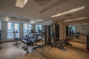 a gym with several treadmills and exercise equipment in a building at HiGuests - Mon Reve in Dubai