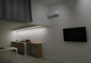 Habitación con TV de pantalla plana en la pared en maison Frima B&B en Matera
