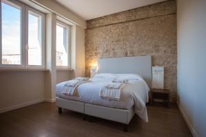 a bedroom with a white bed and two windows at Tre cancelli rooms in Potenza