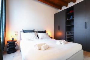 een slaapkamer met een groot wit bed en zwarte kasten bij Primopiano - Zumbini in Milaan