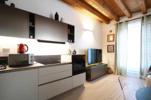 a kitchen with white cabinets and black appliances at Primopiano - Zumbini in Milan