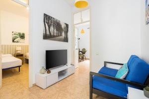 a living room with a blue couch and a tv at Apartaments Clot-Sant Martí in Barcelona