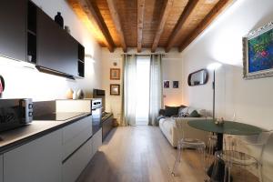 een keuken en woonkamer met een bank en een tafel bij Primopiano - Zumbini in Milaan