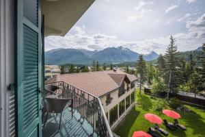 a balcony with red umbrellas and a view of mountains at Cresta Palace Celerina in Celerina