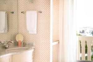 a bathroom with a sink and a window at Hotel Excelsior Venice in Venice-Lido