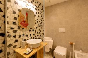 een badkamer met een wastafel, een toilet en een spiegel bij CasAunoE Boutique Hotel in Olbia