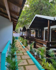 une rangée de cottages dans un complexe avec des plantes dans l'établissement Sand Tent Beach House PALOLEM, à Canacona