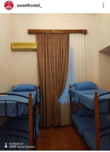 a room with two bunk beds and a curtain at SW HOSTEL by EMIL in Baku