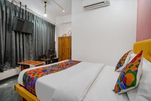 a bedroom with a bed and a tv in it at FabHotel Sky City in Surat
