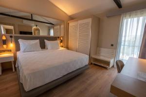 Schlafzimmer mit einem großen weißen Bett und einem Schreibtisch in der Unterkunft LONG BEACH CLUB NATURE - Ultra All Inclusive in Akbük