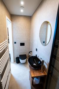 een badkamer met een zwarte wastafel en een spiegel bij Angelinas Service Apartment 1 in Oberhausen