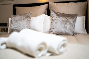 a white bed with pillows and towels on it at Angelinas Service Apartment 1 in Oberhausen