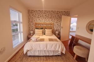 - une chambre avec un grand lit et une fenêtre dans l'établissement House Khasia- on the Golden Mile, à St Helena Bay
