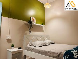 1 dormitorio con cama y pared verde en Sunny Villa Cottage en Sivasagar