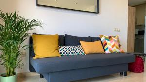 a blue couch with colorful pillows in a living room at Apartamento Los Guirres in Tazacorte