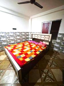a bed with a colorful quilt on it in a room at GRG Sunrise Plaza Deoghar in Deoghar