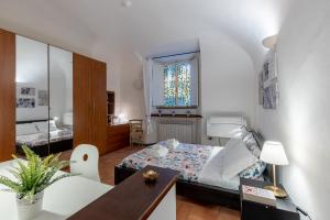 um pequeno quarto com uma cama e uma mesa em Piazza dei Cavalieri Confortable Apartment em Pisa