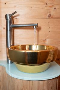 a copper sink with a faucet on a wall at Kleine romantische Hütte in der Semmering-Rax Region in Neunkirchen