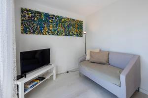 - un salon avec un canapé et une télévision dans l'établissement Casa Kube, à Sagres