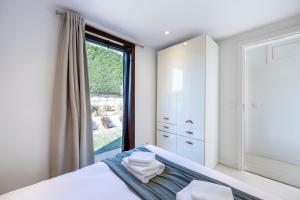 a bedroom with a bed and a large window at Casa Kube in Sagres