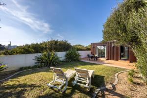 a backyard with two chairs and a house at Casa Kube in Sagres